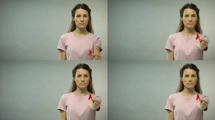 一名年轻女子向镜头展示红丝带，这是国际艾滋病意识的标志