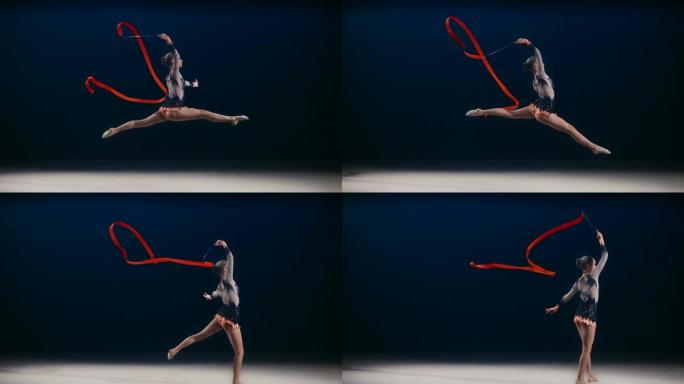 SLO MO SPEED RAMP LD艺术体操运动员在一次跳跃中在头顶上方旋转一条红丝带