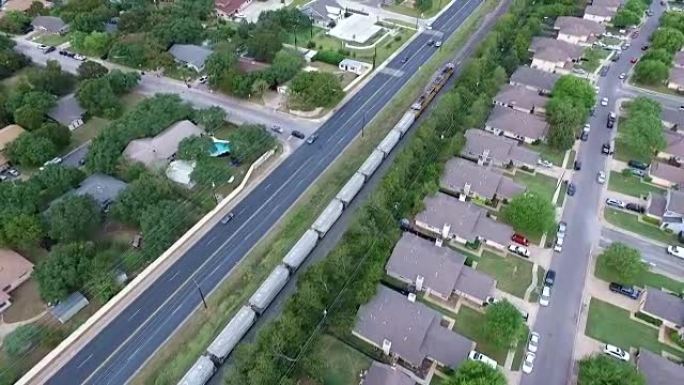 德克萨斯州奥斯汀郊外德克萨斯州中部新现代开发郊区房屋和房屋上方的铁路列车运输