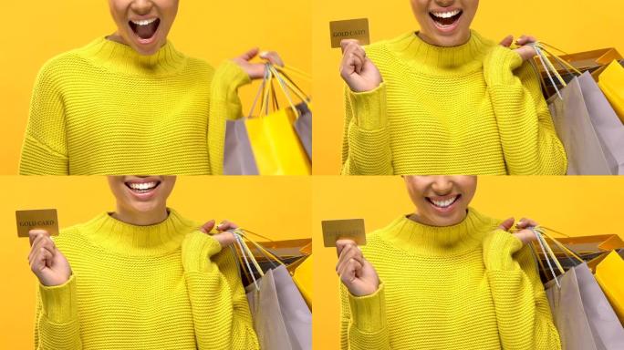 女性购物狂带购物袋显示黄金信用卡明亮背景