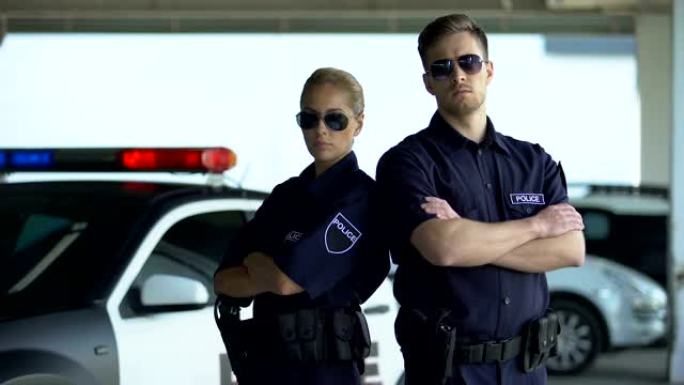 勇敢的女警和戴着墨镜的男人站在汽车旁，双手合十