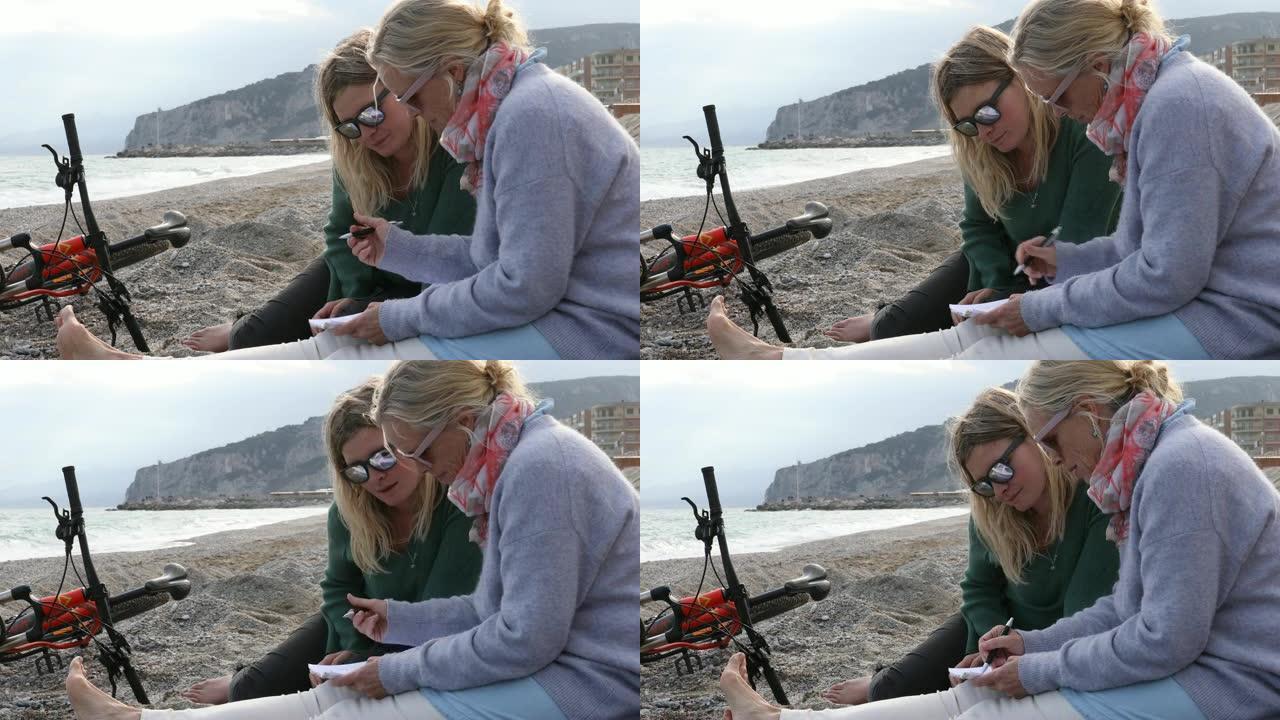 母女俩在沙滩上放松身心，用写字板