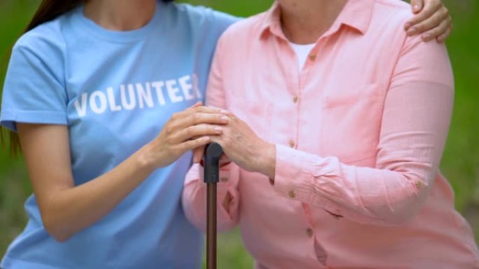 社会志愿者用手杖抚摸老病人的手，临终关怀支持