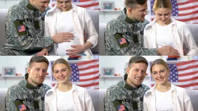 年轻的士兵和期待的妻子在镜头前微笑抚摸着肚子，安全的未来