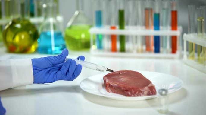 实验室工作人员向肉类样品中注射药物，进行非洲猪流感分析