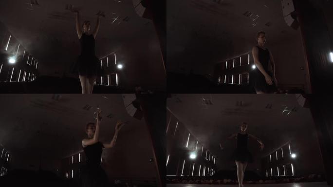 慢动作: 穿着黑色连衣裙的prima ballet进行旋转，并在排练独奏节目时跳舞优美的动作。摄像机