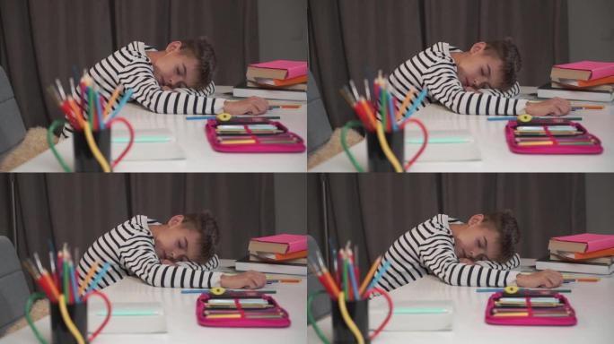 一个白人小男孩睡在桌子上的特写脸。小学生在家做作业后累了。可爱的孩子穿着条纹夹克学习后筋疲力尽。
