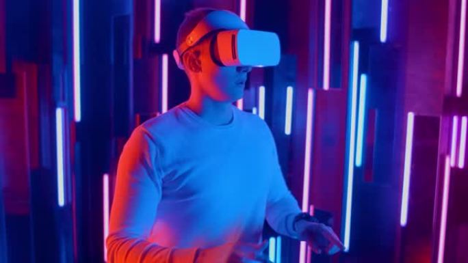 戴着虚拟现实耳机的男子在黑暗空间照明霓虹灯中玩耍时左右快速倾斜。