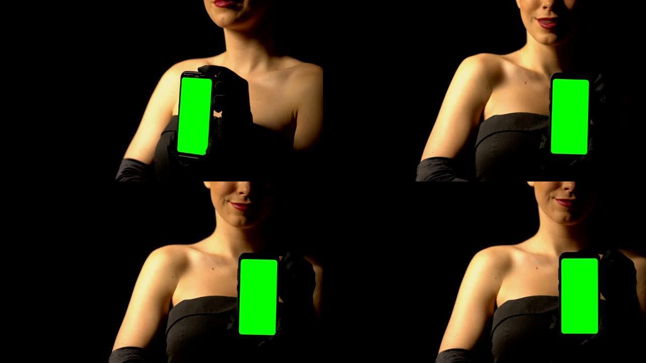 穿着优雅连衣裙的女人展示绿屏智能手机，在线赌场