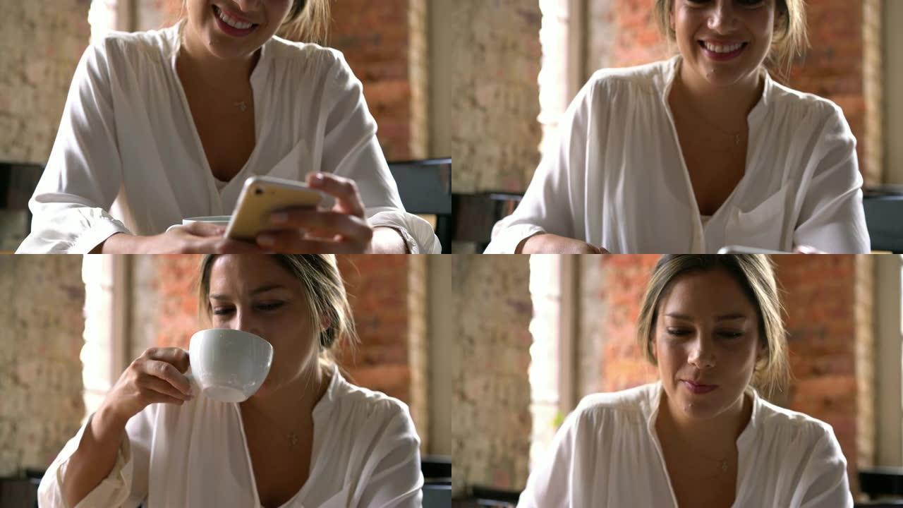 美女在面包店喝茶时在智能手机上聊天的特写镜头