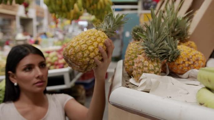 农贸市场上漂亮的女顾客从看台上抢菠萝