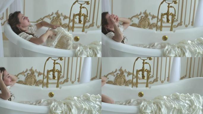 穿着白色婚纱的年轻女子躺在令人惊叹的ampty浴池中，女孩用鲜花摘下帽子，抛向空中