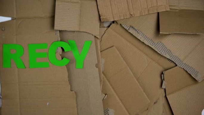 回收纸板背景上的绿色字母制成的单词，拯救星球