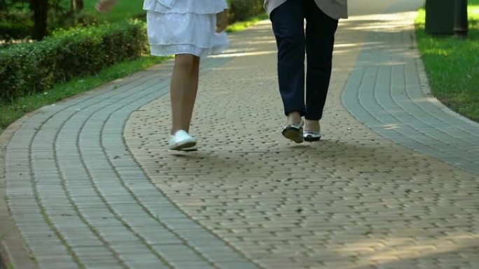 残障小孩在诊所附近与年长的护士一起散步