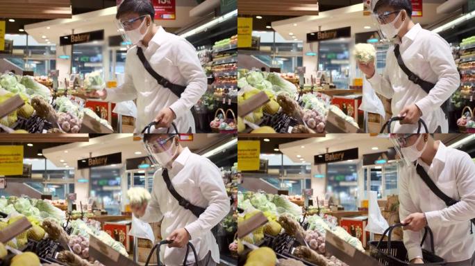 亚洲男人戴着面具保护和他在超市购物。