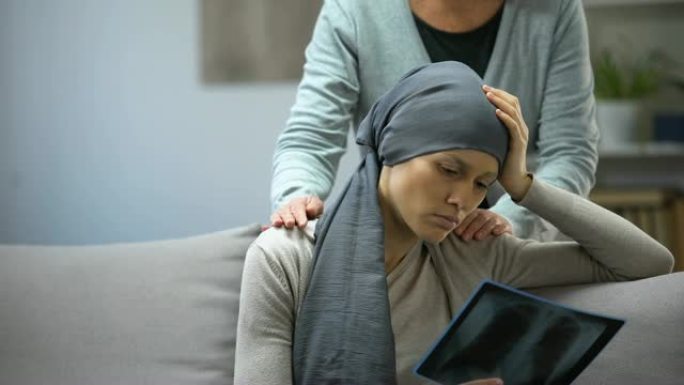 患有癌症的女人看着x射线，母亲抚养女儿，病情恶化