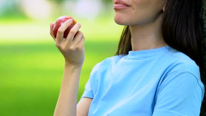 美女户外吃甜苹果，健康零食，维生素，营养