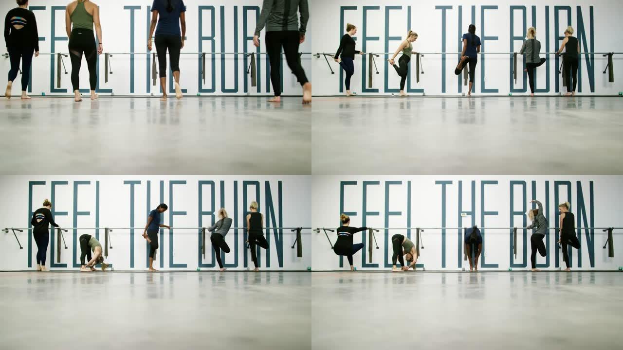 一个由五个二十多岁的妇女组成的多种族团体走到芭蕾舞鞋前，开始在健身室里伸展运动