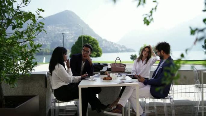 一群商务旅客与早餐会面，俯瞰湖泊