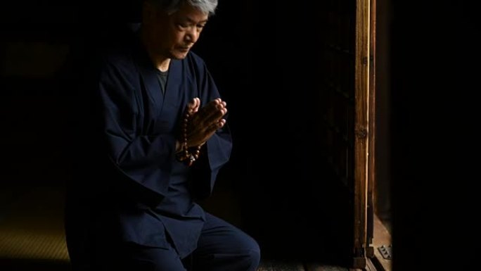 日本高级男子在寺庙祈祷
