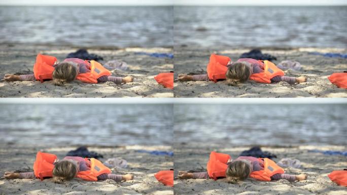 穿着救生衣的小女孩躺在海边，自然灾害洪水的幸存者