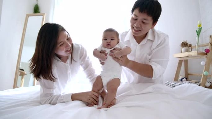 4k慢动作，父亲和母亲互相帮助，婴儿开始走路。