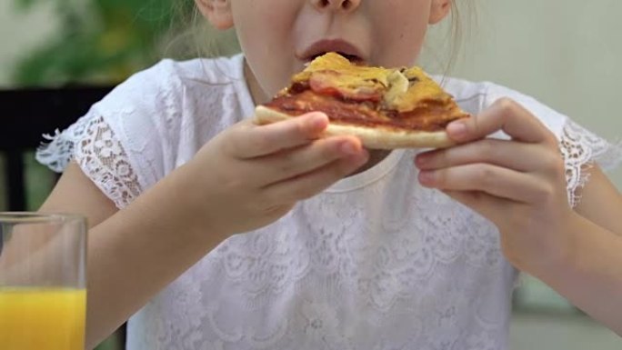 女孩吃陈旧的油炸比萨饼，不健康的垃圾食品，肥胖的风险
