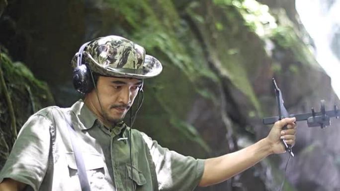 研究人员收听无线电遥测的无线电信号，跟踪寻找热带雨林中的野生动物