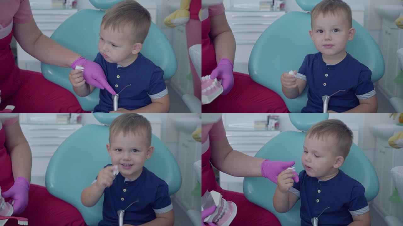 坐在椅子上无忧无虑的小男孩。可爱的男孩在玩牙植入物。