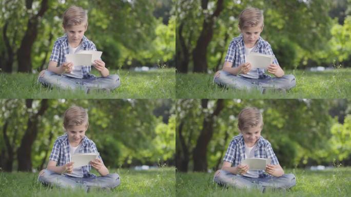 穿着方格衬衫的可爱男孩在公园里看着床单的肖像。