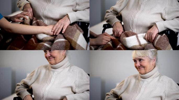 女人用格子轻轻遮盖老残障女性，志愿者支持