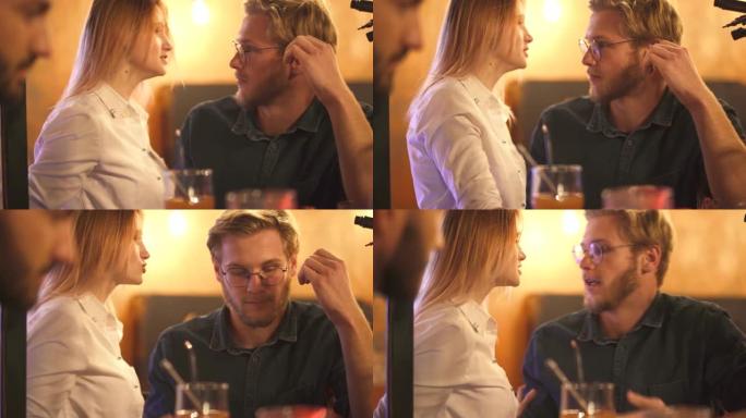 两个男人和一个女孩在餐桌旁的咖啡馆里大笑