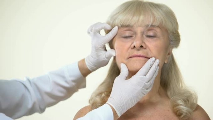 皮肤科医生检查老年女性患者的皮肤，去除皱纹，美容