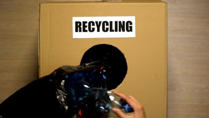 回收写在盒子上，女性手把塑料瓶放在里面，利用