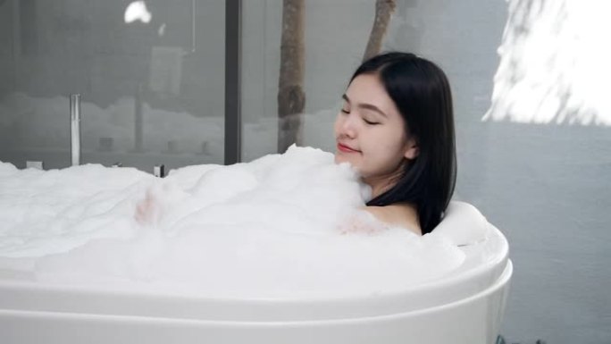 4k亚洲女孩她正在热水浴缸里洗澡。