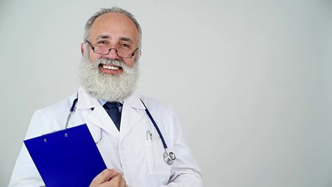 成人高级医生微笑着看着灰色背景上的相机