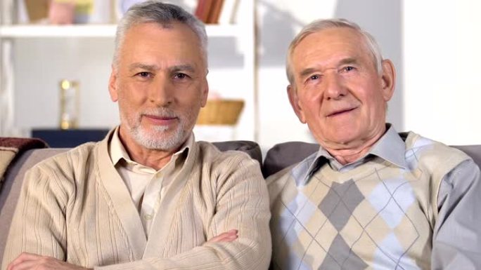 高兴的老人看着相机，微笑着，幸福的退休，成功和财富