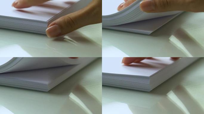 手工翻阅厚厚的白纸，文件，排版特写