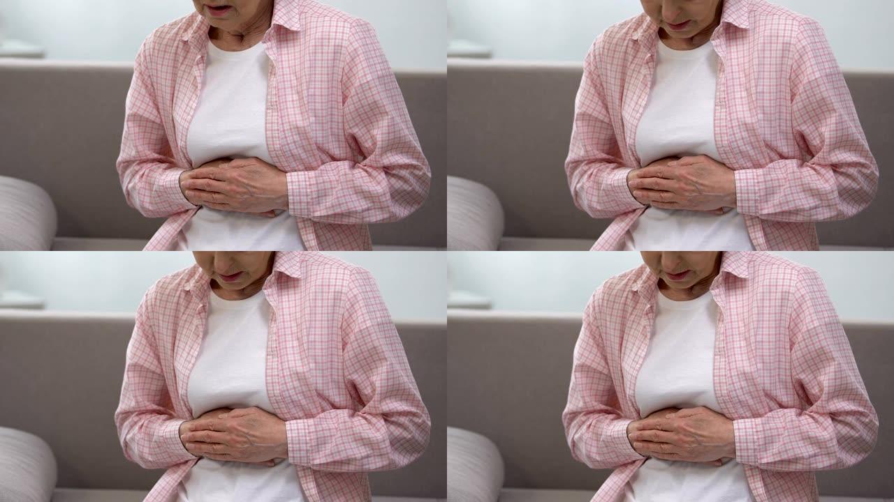 老年妇女抱着胃，患有胃炎问题，保健