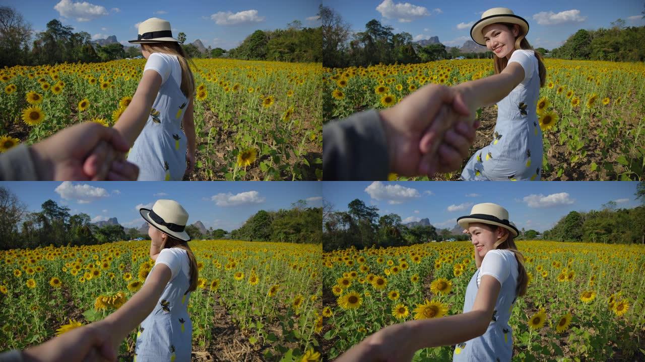 慢动作美丽的泰国亚洲女人，她来参观向日葵的黄色田野。