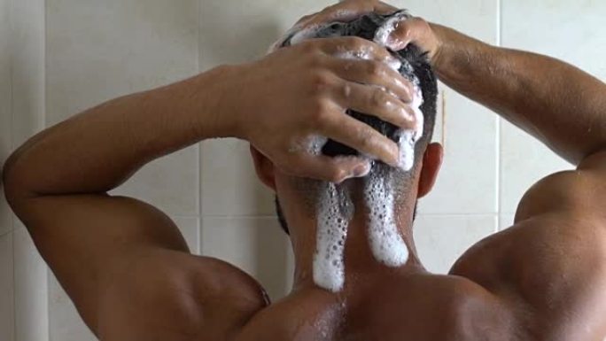 运动的男人在精疲力竭的锻炼后洗澡，完美的身体，洗头