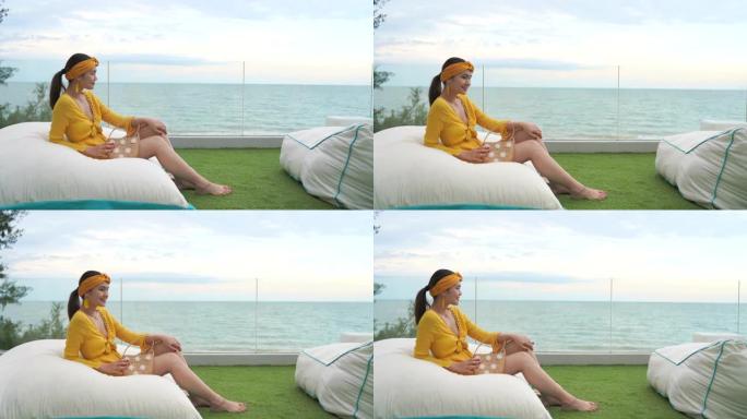 4k镜头美女坐在沙滩上的软垫上
