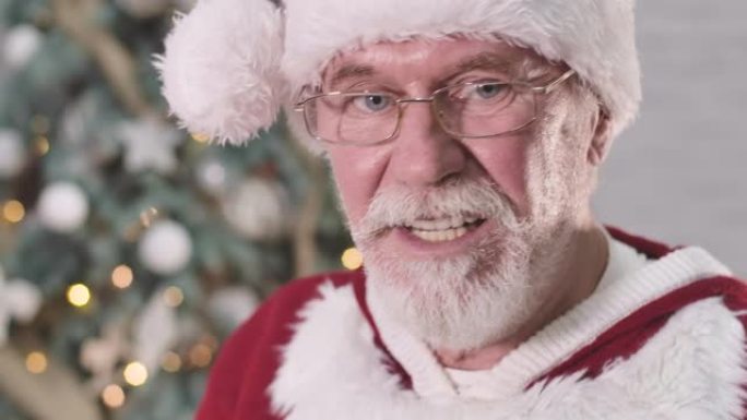 圣诞老人的脸在眼镜上的极端特写使脸不高兴，看着相机，摇头和签名。白胡子老人厌倦了圣诞节的愿望。电影院