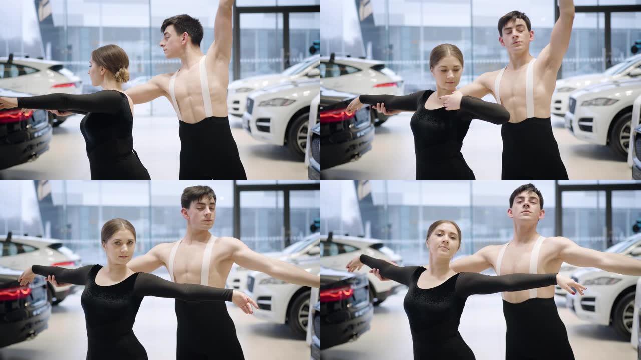 专业的高加索芭蕾舞演员用手做动作，看着相机，微笑着。自信的男人和女人在汽车经销店跳舞经典舞蹈。汽车工
