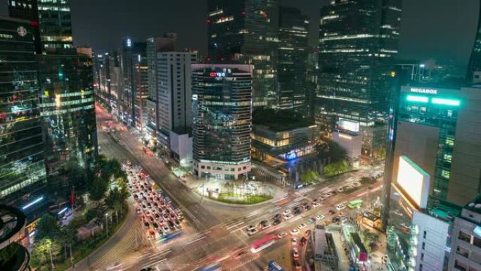 在韩国首尔市汉城江南中心商业区的一个十字路口，光线小径的延时日落场景交通速度加快。