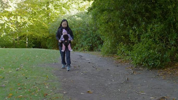 亚洲妈妈带着女儿在森林公园散步