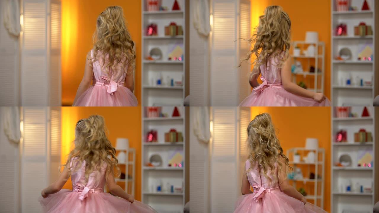 可爱的小女孩穿着粉色连衣裙跳舞，假装是公主，幸福
