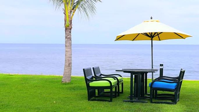 海洋附近草地上的黄色沙滩伞和椅子