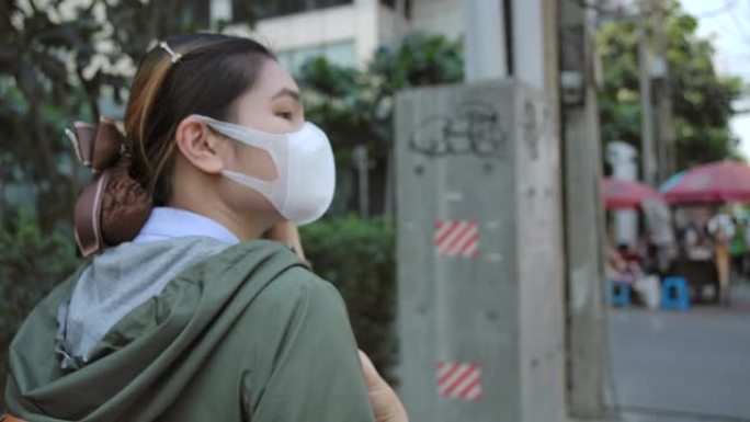 4k亚洲女性戴着鼻罩，防止空气中PM 2.5灰尘和Covid病毒。