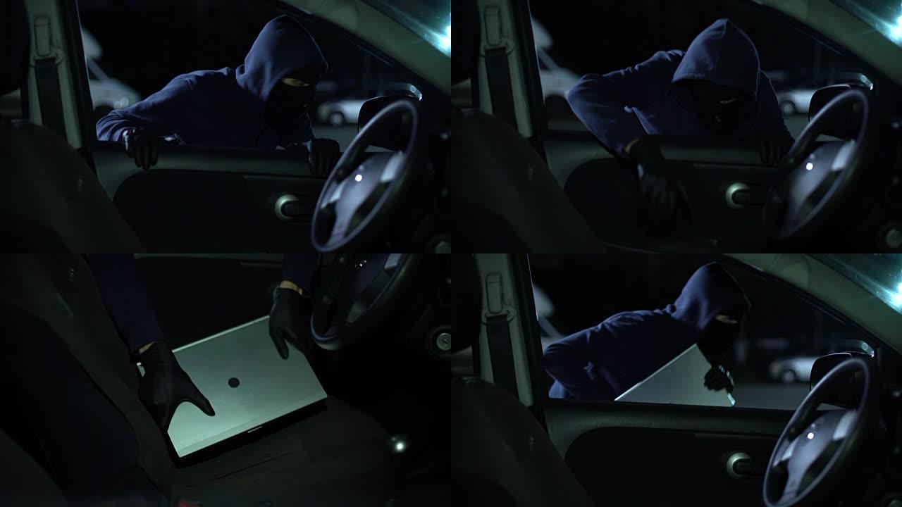 强盗在夜间从开着的汽车偷笔记本电脑，安全系统，粗心
